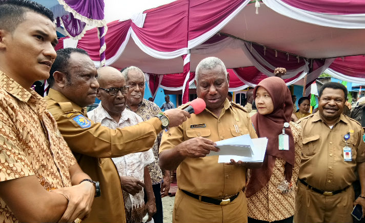 Gubernur Papua Barat, Domingus Mandacan menyerahkan kartu BPJS Kesehatan kepada Warga Wirsi Manokwari. (dhy)