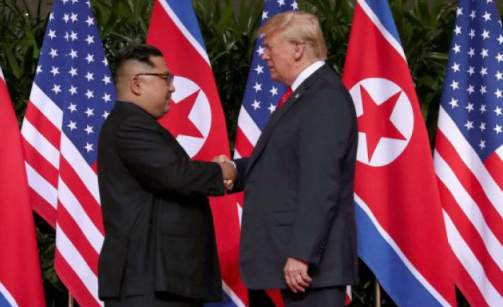 Donald Trump berjabat tangan dengan Kim Jong Un