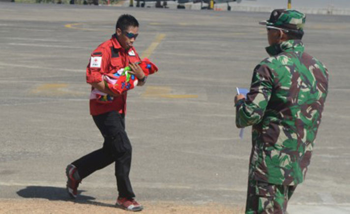 Seorang Relawan Mengevakuasi Bayi