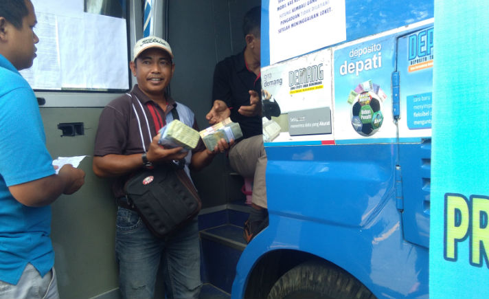 Seorang warga melakukan penukaran uang di salah satu perbankan di Benteng Kuto Besak