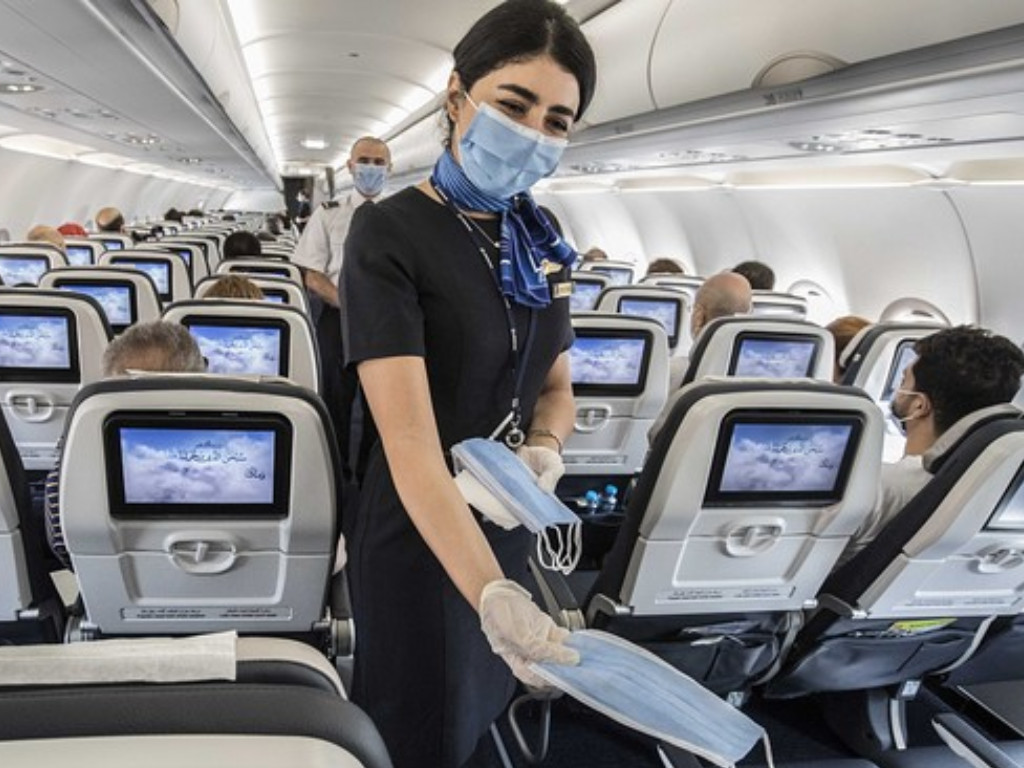 Menggunakan masker di pesawat