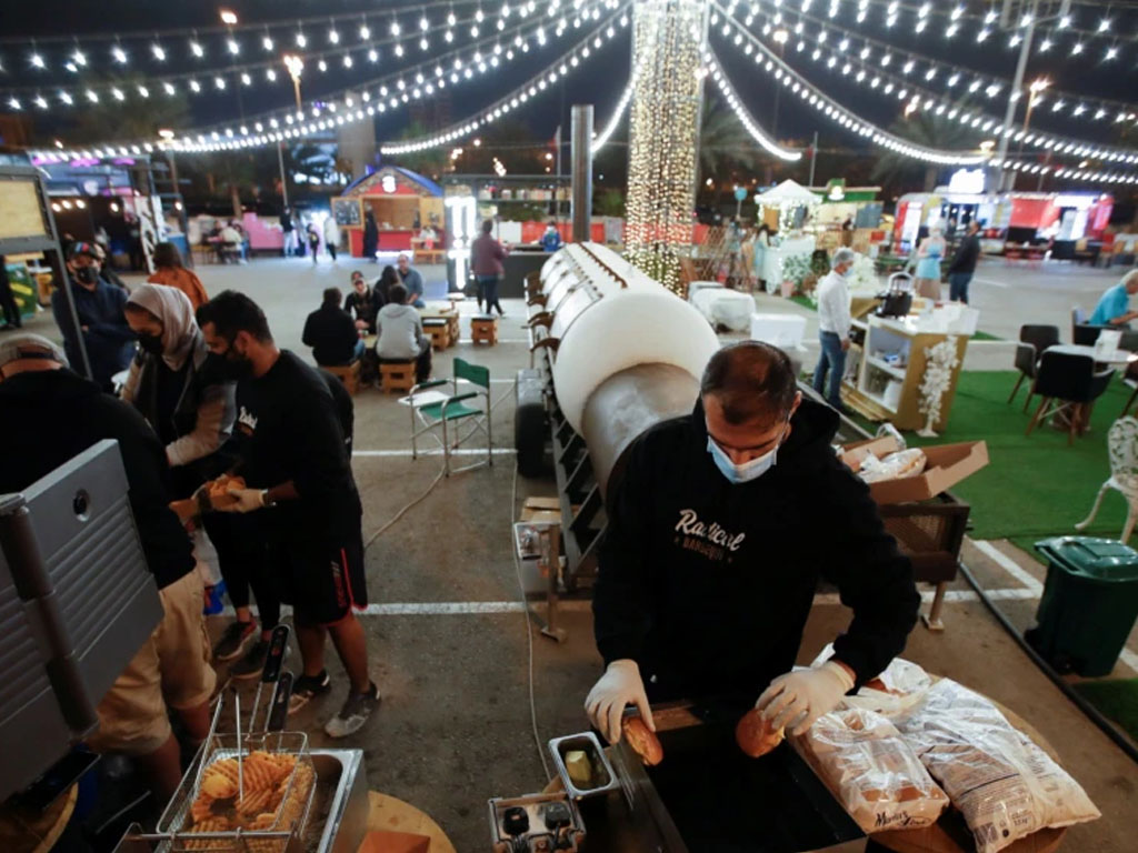 Seorang penjual menyiapkan hamburger