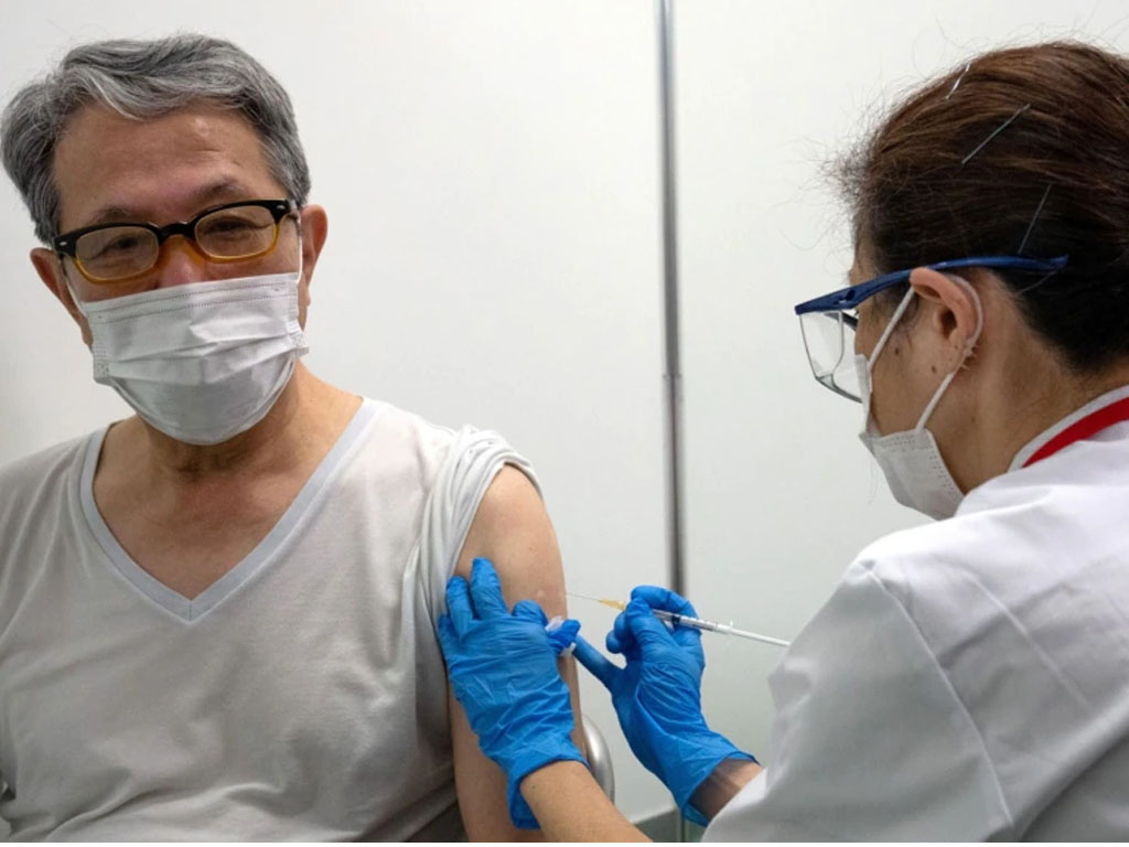 pria lansia terima vaksin covid di tokyo