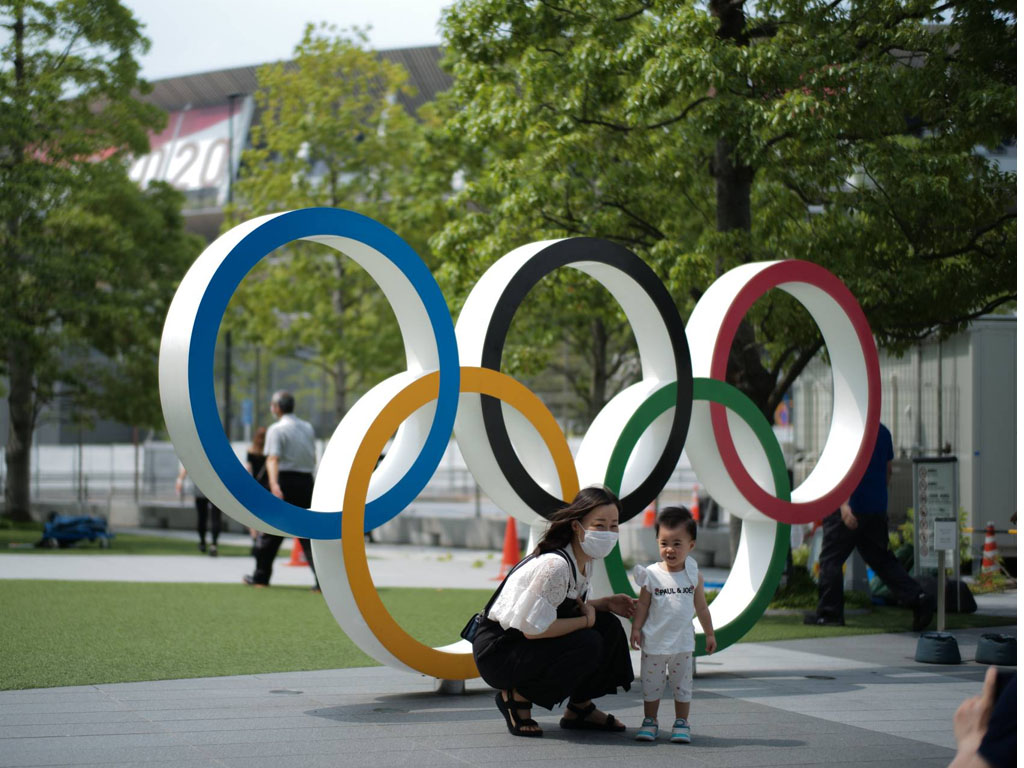 seorang ibu dan anaknya berpose di ring olimpiade tokyo