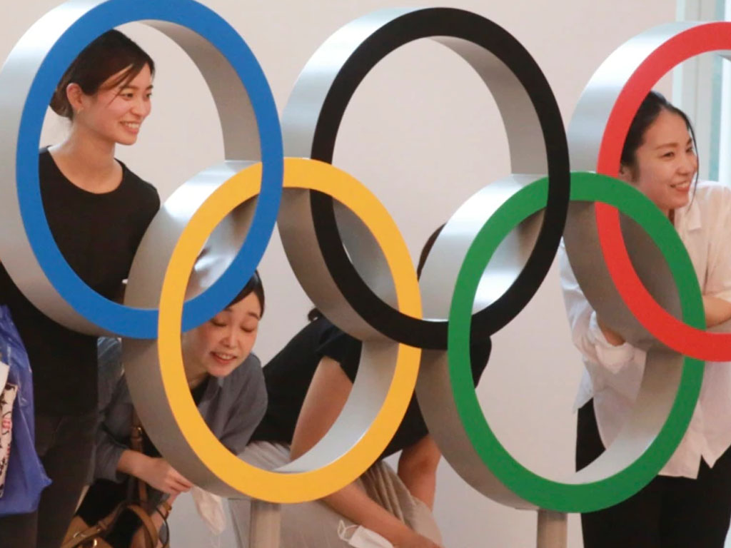 Penumpang berpose dengan logo Cincin Olimpiade