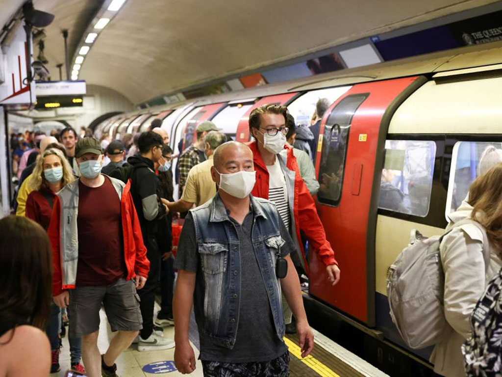 warga pakai masker di peron kereta bawah tanah di London