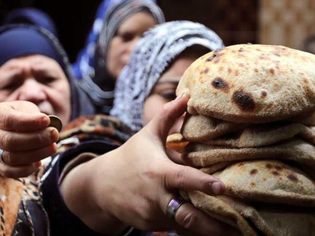 Penduduk antre membeli roti di sebuah pojok Kairo