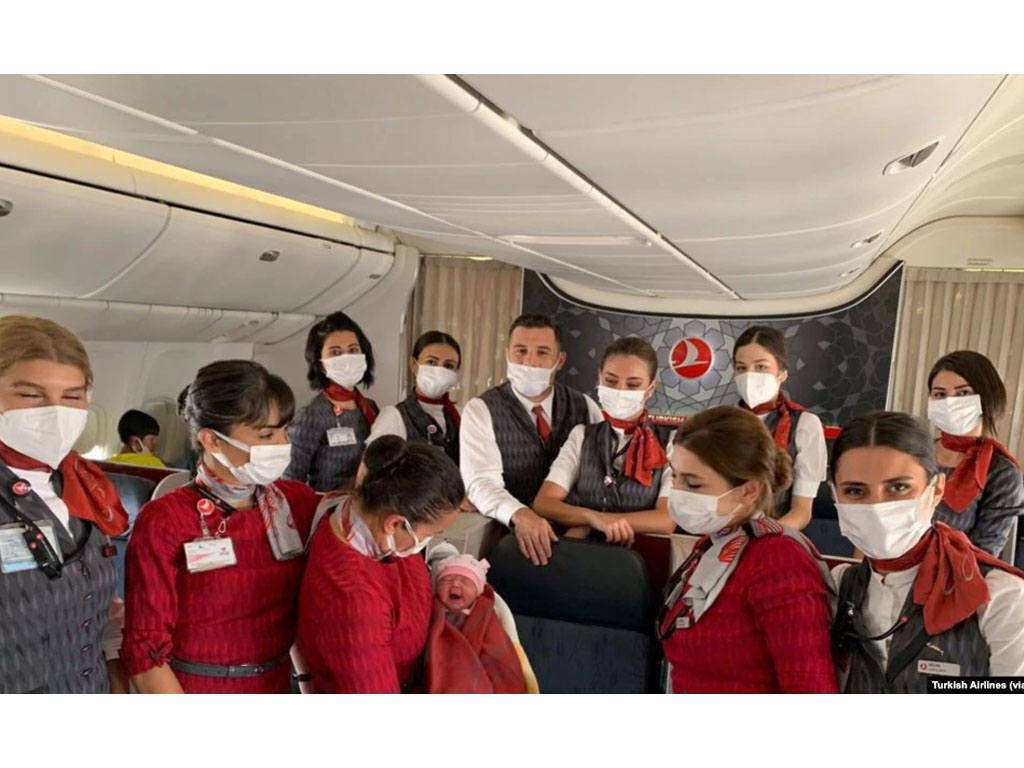 Awak kabin Turkish Airlines berpose dengan bayi