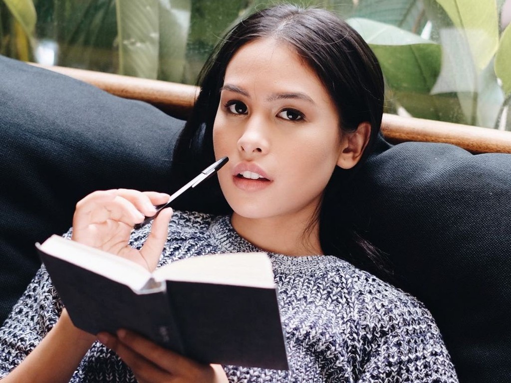 Maudy Ayunda membaca buku