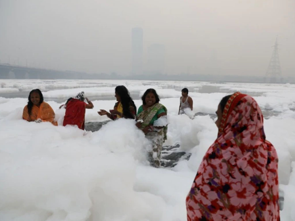 Para perempuan mandi di air sungai Yamuna