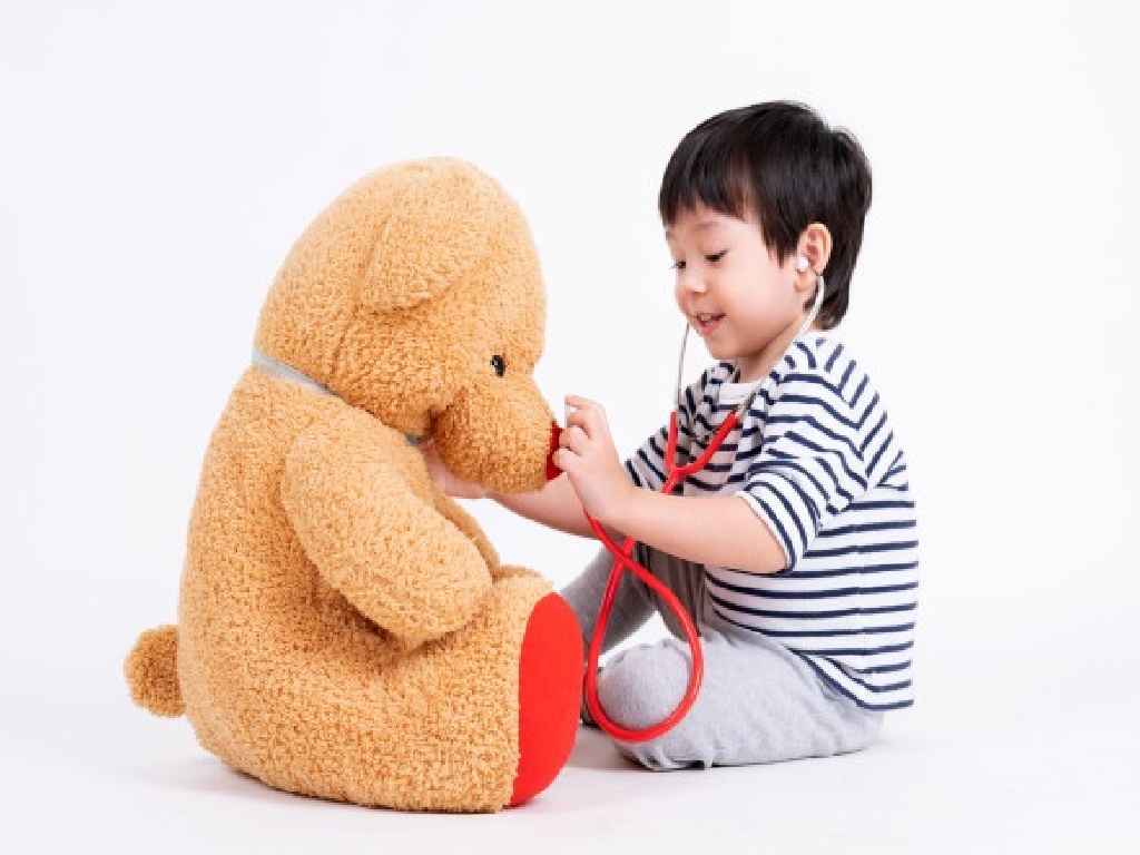 Anak kecil sedang bermain boneka