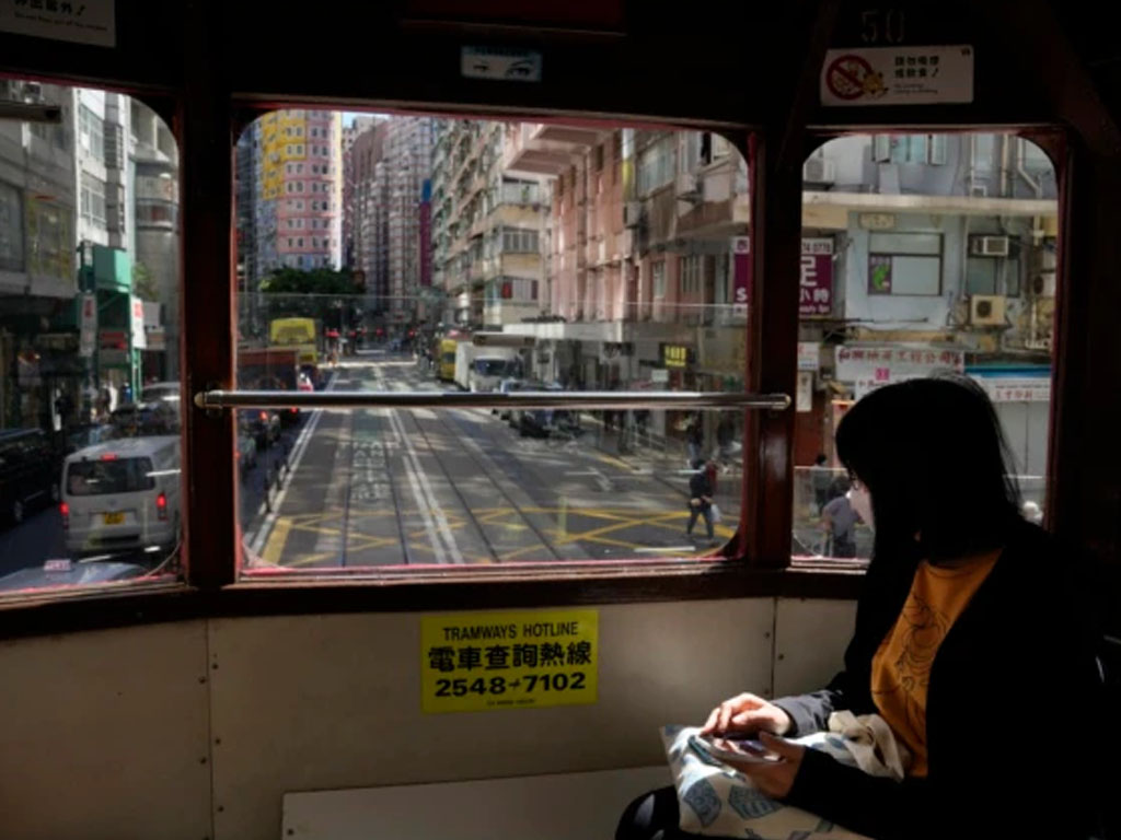 perempuan pakai masker naik trem di hong kong