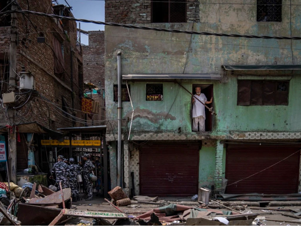 seorang pria di reruntuhan bangunan di new delhi