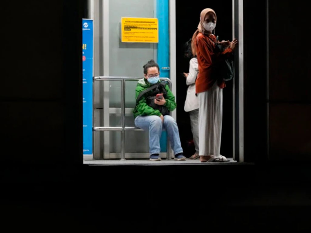 warga pakai masker di halte bus