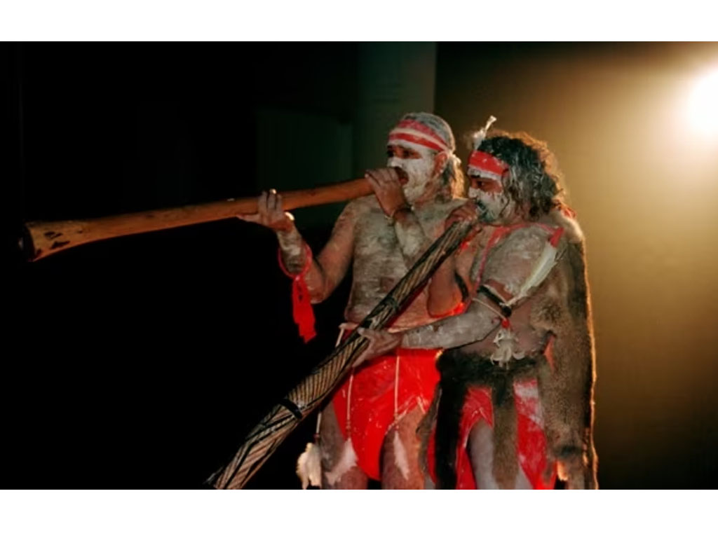 pria aborigin mainkan alat musik tradisional