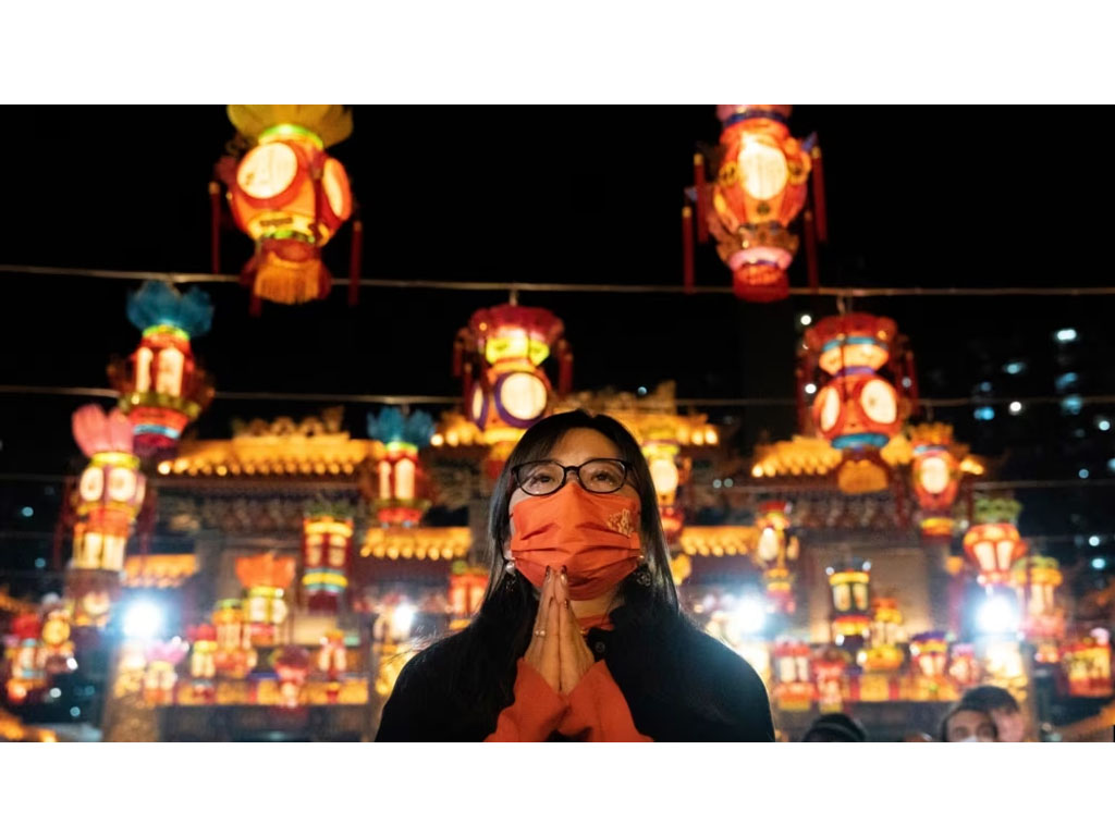 perempuan pakai masker berdoa di kuil di hong kong
