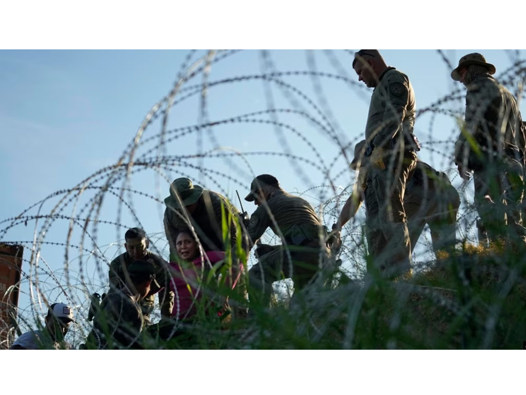 migran menerobos pagar kawat di perbatasan meksiko
