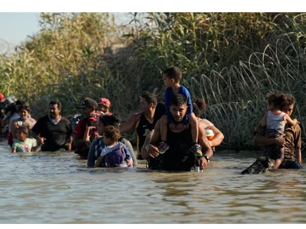 pria gendong anak seberangi sungai di perbatasan meksiko