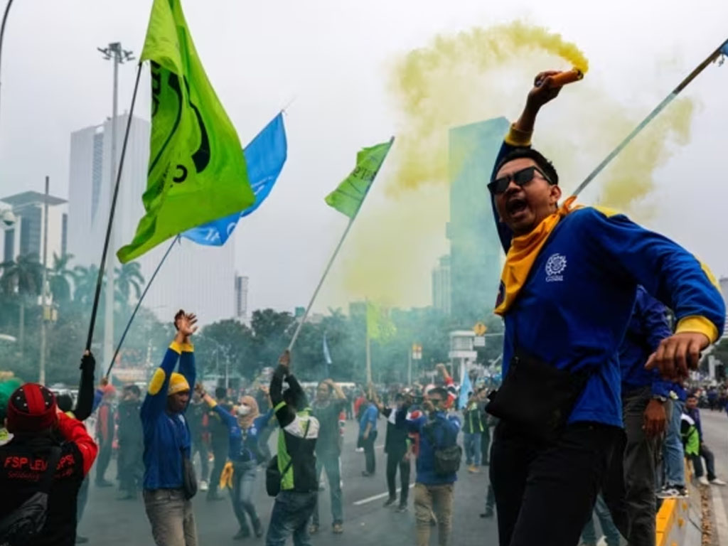 Seorang buruh memegang alat pembuat asap