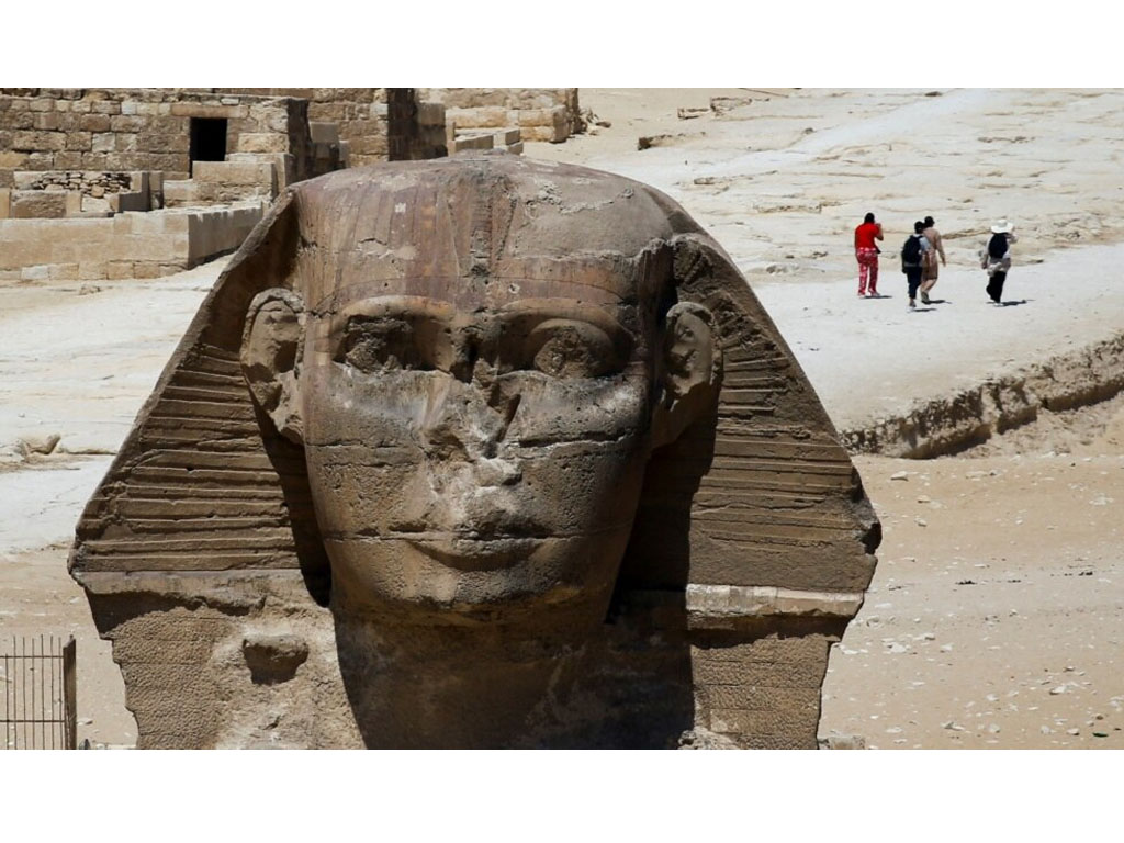 Pengunjung berjalan di dekat patung Sphinx