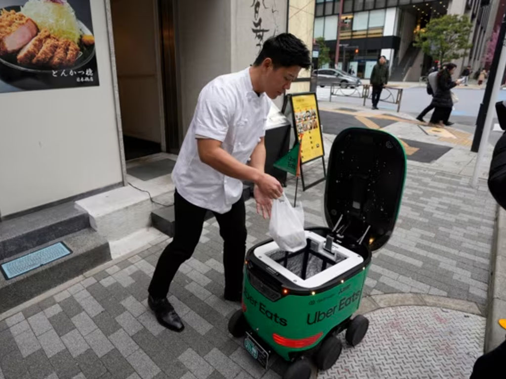 karyawan isi makanan ke robot di tokyo