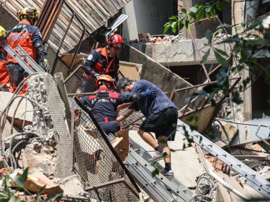 pekerja darurat membantu seorang korban gempa taiwan