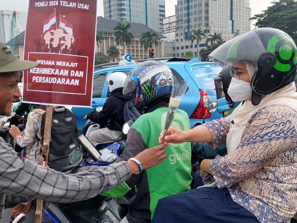 Aliansi Muda untuk Demokrasi Bagi-bagi Bunga Mawar Ajak Masyarakat Bersatu Setelah Pilpres 2024