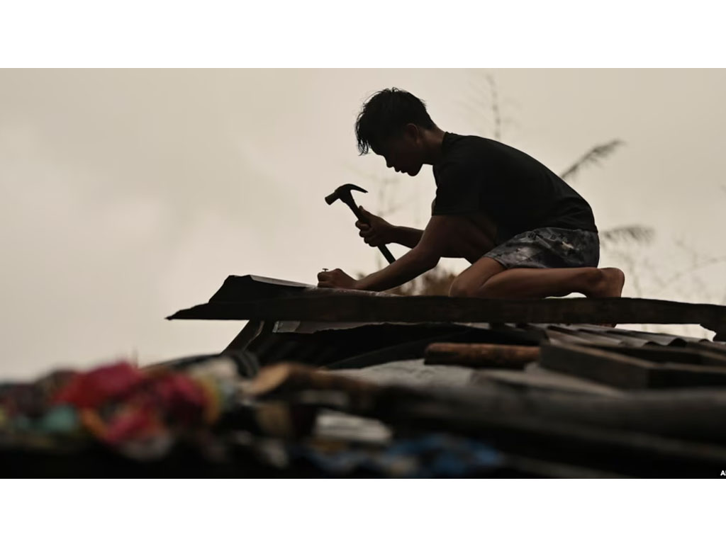 pria di filipina perkuat atap rumahnya