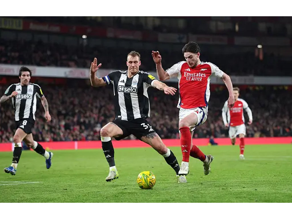 peman Arsenal menggiring bola